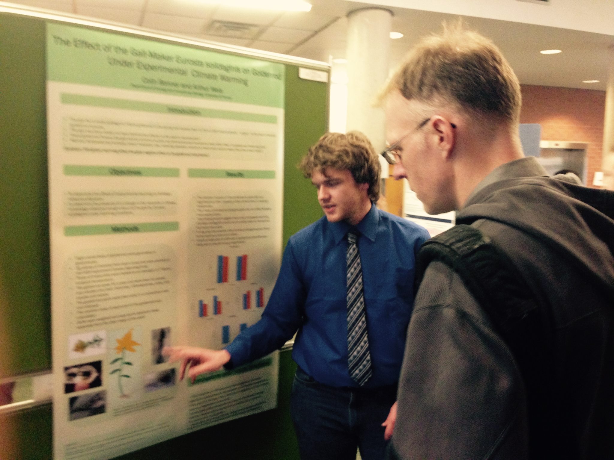 Colin Bonner explain his 2014 undergraduate research poster to Ben Gilbert.